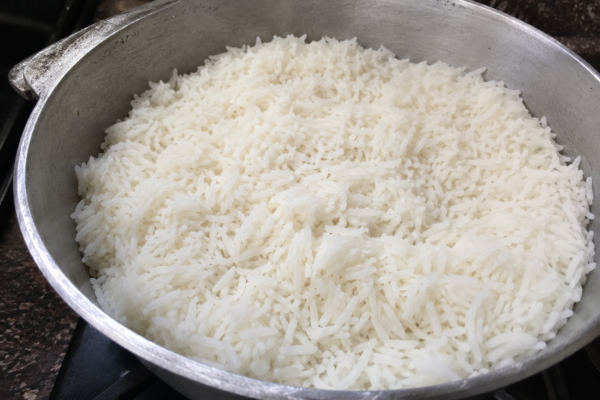 Arroz branco soltinho fumegante em panela de alumínio batido, típico da culinária mineira.